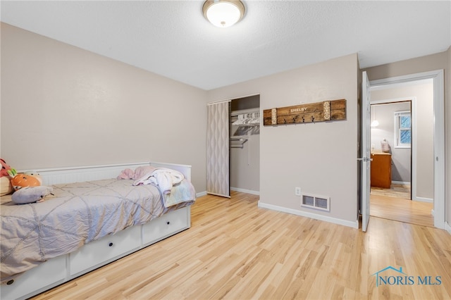 bedroom featuring a textured ceiling and light wood-type flooring