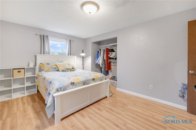 bedroom with hardwood / wood-style flooring, a closet, and a textured ceiling