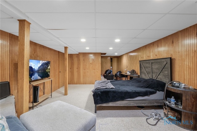 carpeted bedroom with wood walls