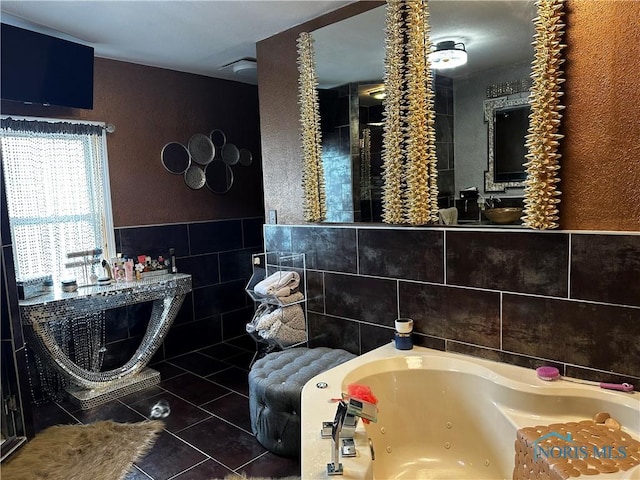 bathroom featuring tile patterned flooring, a bathtub, and tile walls