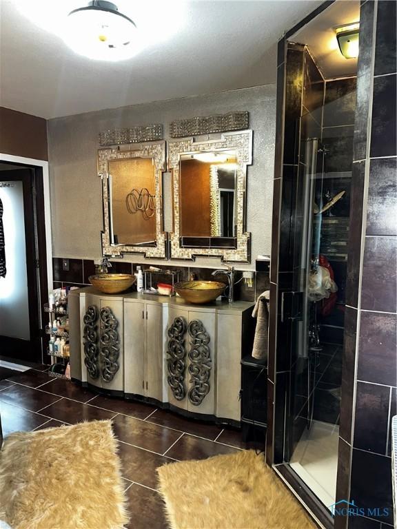 bathroom featuring tile patterned floors, vanity, and a shower with shower door