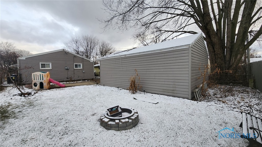 yard covered in snow featuring a fire pit