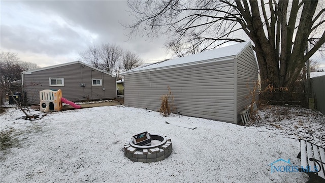 yard covered in snow featuring a fire pit