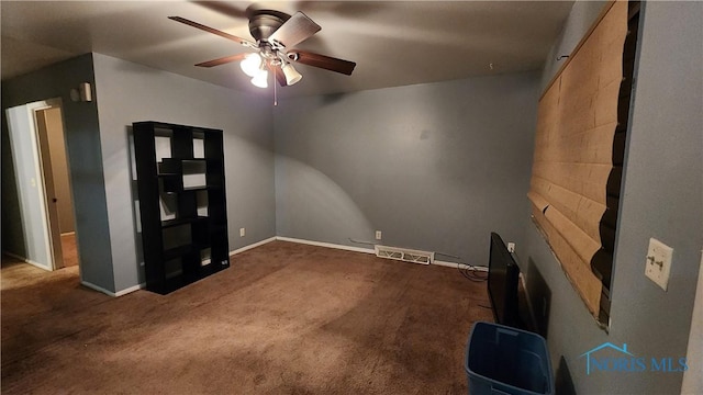 interior space with visible vents, dark carpet, and ceiling fan