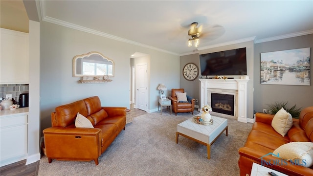 living room with ornamental molding, light colored carpet, and ceiling fan