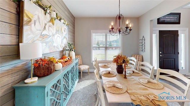 dining space featuring carpet flooring and a chandelier