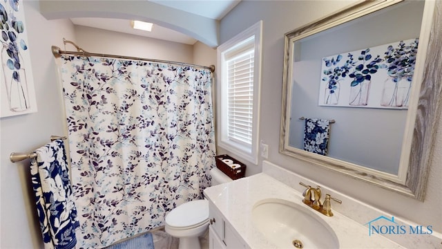 bathroom featuring vanity, a shower with shower curtain, and toilet