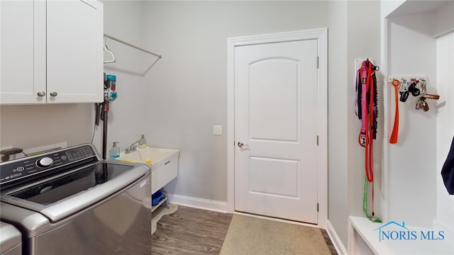 laundry area with cabinets, separate washer and dryer, sink, and dark hardwood / wood-style flooring