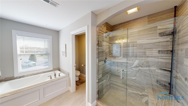 bathroom featuring separate shower and tub and toilet