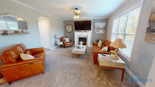 living room with plenty of natural light, ornamental molding, and carpet flooring