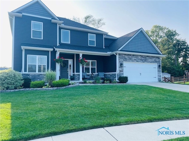 view of front of home with a garage, a front lawn, and covered porch