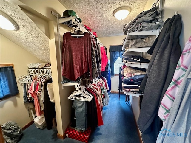 walk in closet featuring dark colored carpet