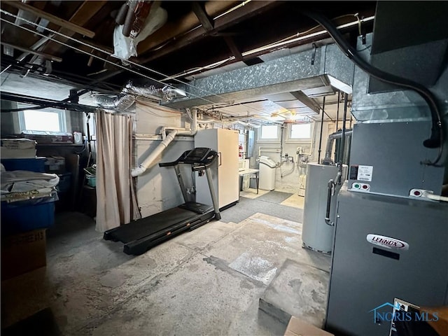 basement with water heater, plenty of natural light, heating unit, and electric panel