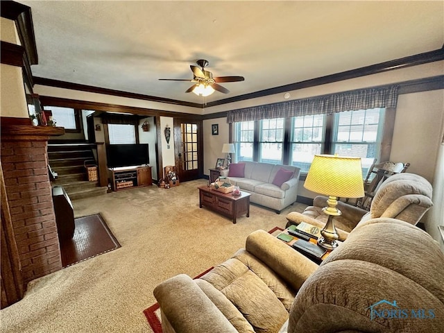 carpeted living room with ornamental molding and ceiling fan