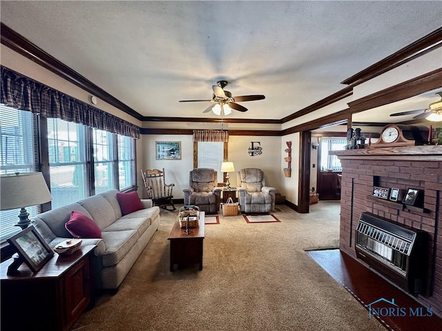 carpeted living room featuring ceiling fan, ornamental molding, a fireplace, and heating unit