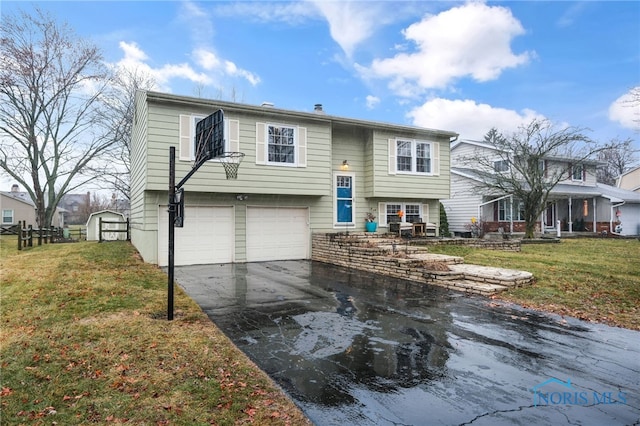 split foyer home featuring a garage and a front lawn