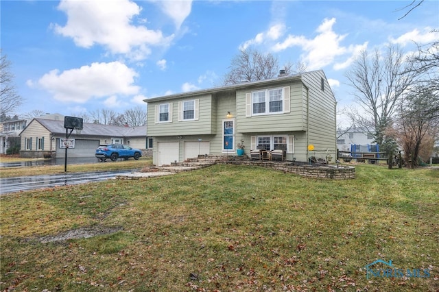 split foyer home featuring a garage and a front lawn