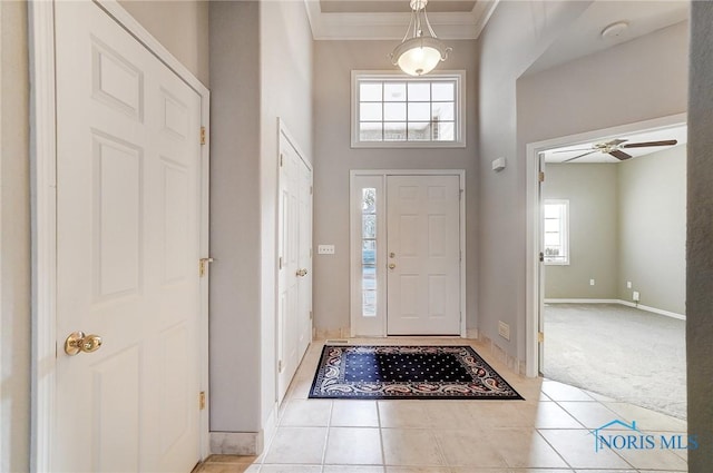 entrance foyer with crown molding, light tile patterned floors, and ceiling fan