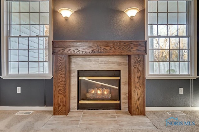 interior details featuring a tile fireplace