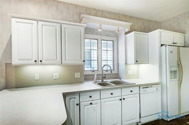 kitchen featuring white cabinetry, sink, and white appliances