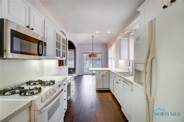 kitchen with pendant lighting, sink, white cabinets, dark hardwood / wood-style flooring, and white appliances