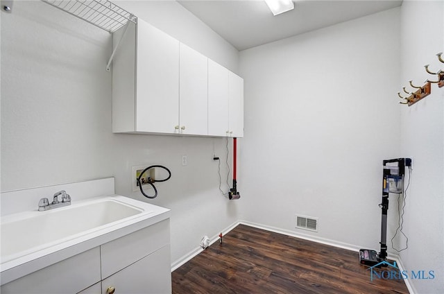 clothes washing area with cabinets, sink, dark hardwood / wood-style floors, and washer hookup