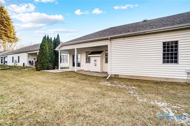 back of house with a yard and a patio