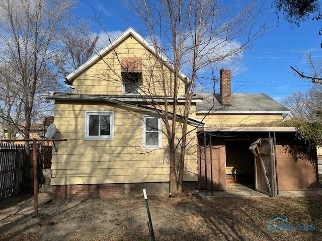 rear view of house with fence and a chimney