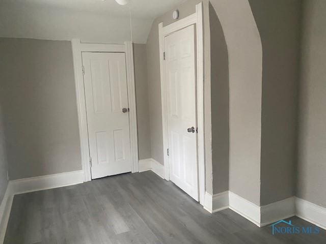 interior space featuring a closet, wood finished floors, and baseboards