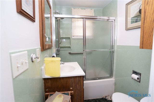 full bathroom featuring enclosed tub / shower combo, vanity, and toilet