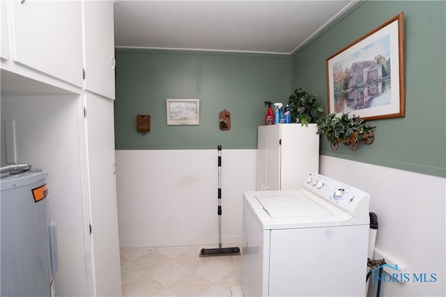 clothes washing area with washer / clothes dryer, cabinets, and water heater