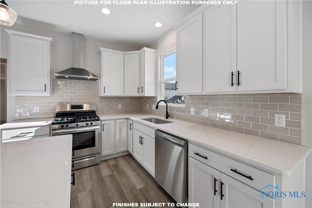 kitchen with white cabinets, appliances with stainless steel finishes, sink, and wall chimney range hood