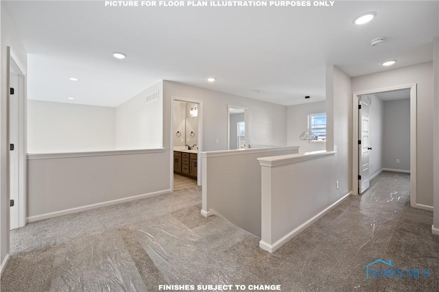 hallway featuring sink and light colored carpet