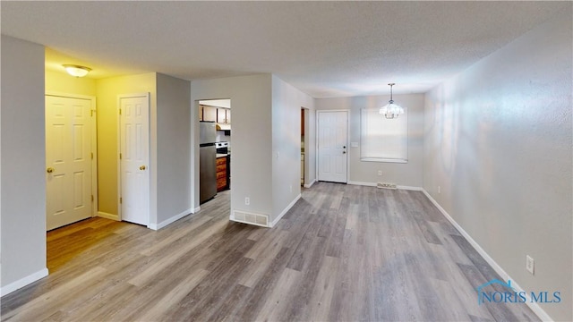 interior space featuring hardwood / wood-style flooring, a notable chandelier, and a textured ceiling