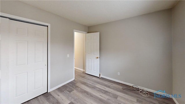 unfurnished bedroom featuring light hardwood / wood-style flooring and a textured ceiling