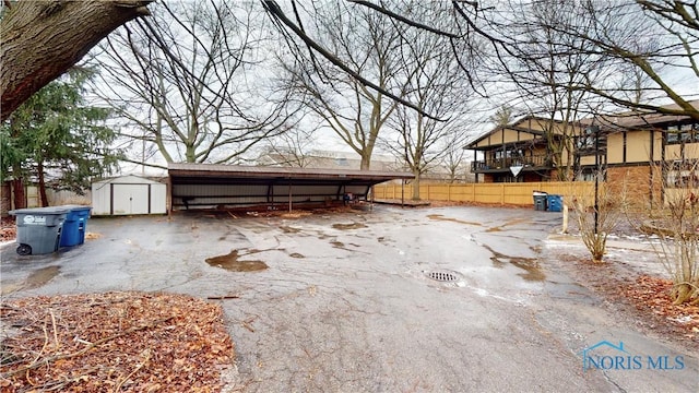 view of patio / terrace with a carport and a storage unit