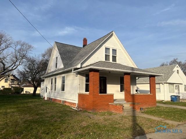 view of front of property with a porch and a front lawn