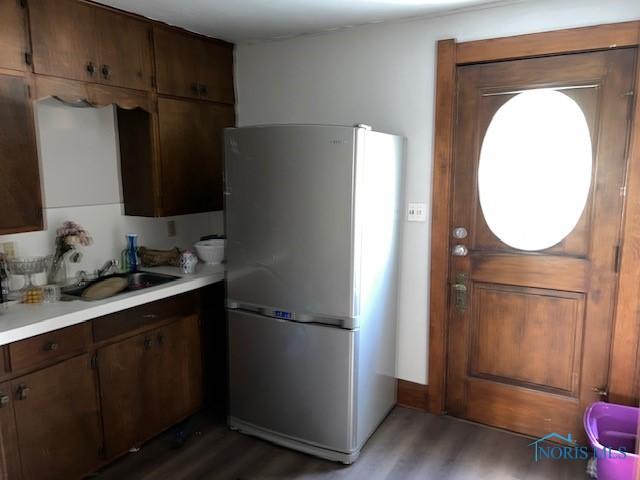 kitchen featuring stainless steel refrigerator, dark wood-type flooring, and sink