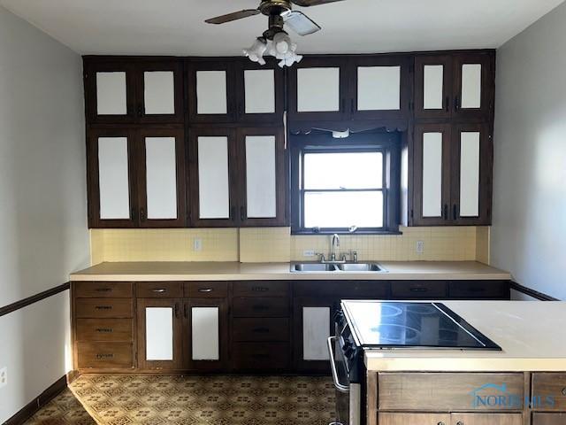 kitchen featuring tasteful backsplash, sink, stainless steel electric stove, and ceiling fan