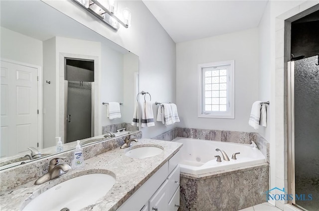 bathroom featuring vanity and independent shower and bath