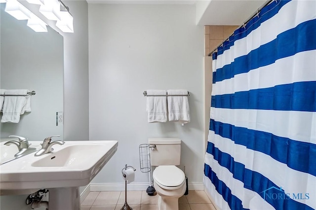 bathroom with sink, toilet, curtained shower, and tile patterned flooring