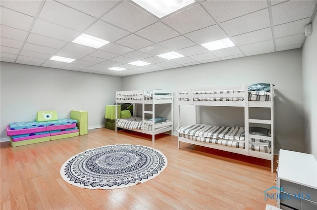 bedroom featuring hardwood / wood-style floors and a drop ceiling