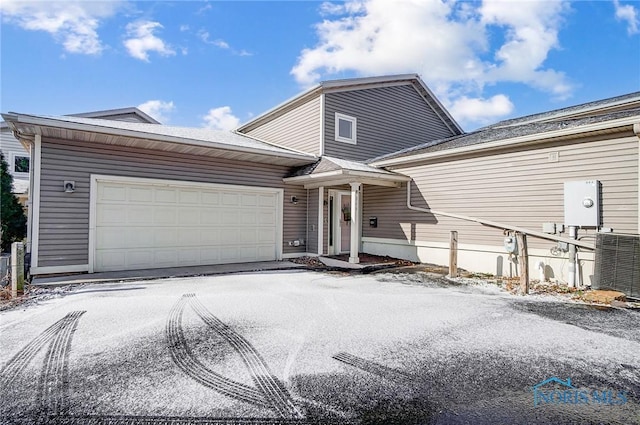 view of front of property with a garage and central air condition unit