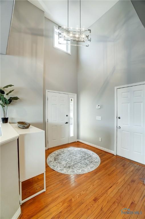 foyer featuring a high ceiling, hardwood / wood-style floors, and a chandelier