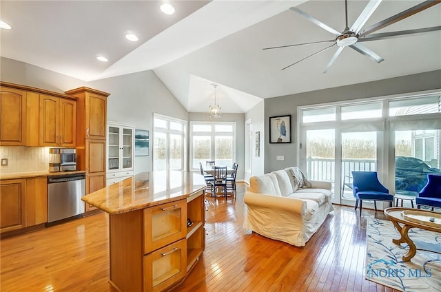 kitchen with decorative light fixtures, light hardwood / wood-style flooring, dishwasher, and a kitchen island