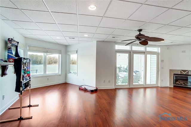 interior space with wood-type flooring, a paneled ceiling, and ceiling fan