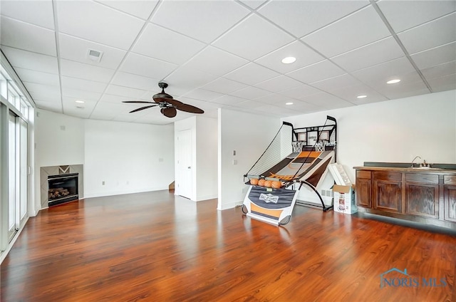 interior space featuring ceiling fan, a paneled ceiling, and dark hardwood / wood-style flooring