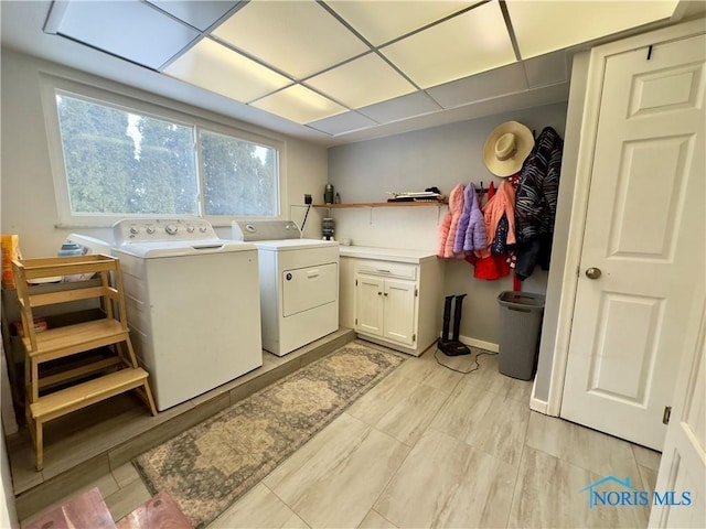 laundry room with washer and dryer and cabinets