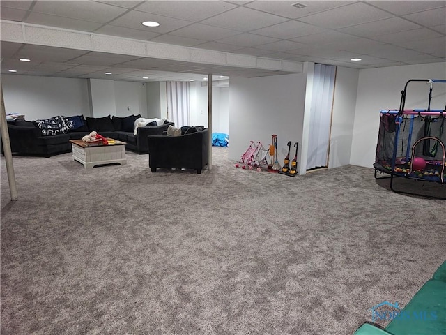 living room featuring carpet and a drop ceiling