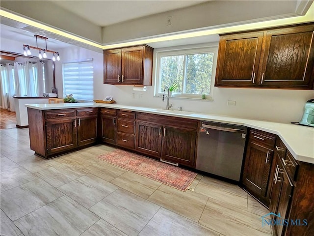 kitchen with stainless steel dishwasher, kitchen peninsula, sink, and hanging light fixtures